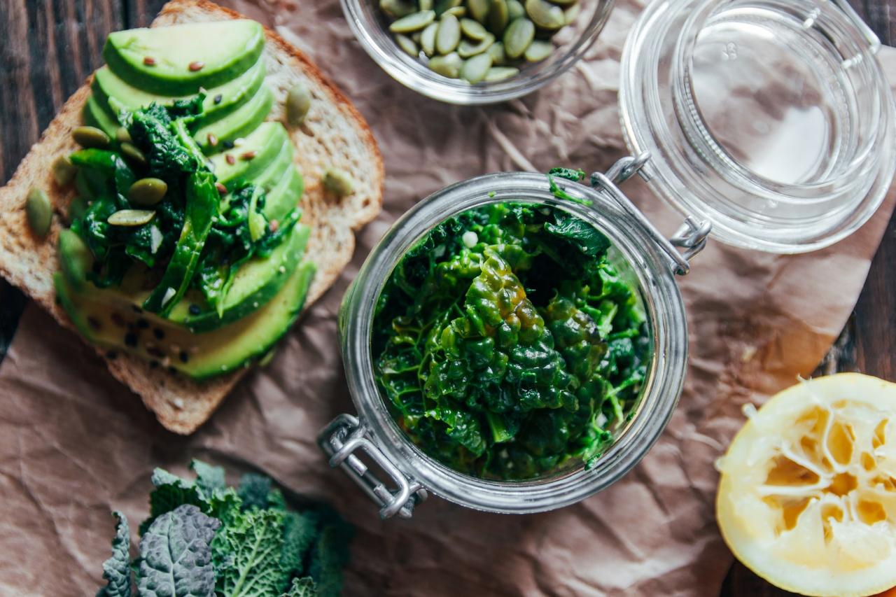 ​​Healthy food spread of avocado on toast and leafy greens​ 