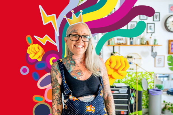 Woman with grey hair, glasses, and tattoos smiling at camera