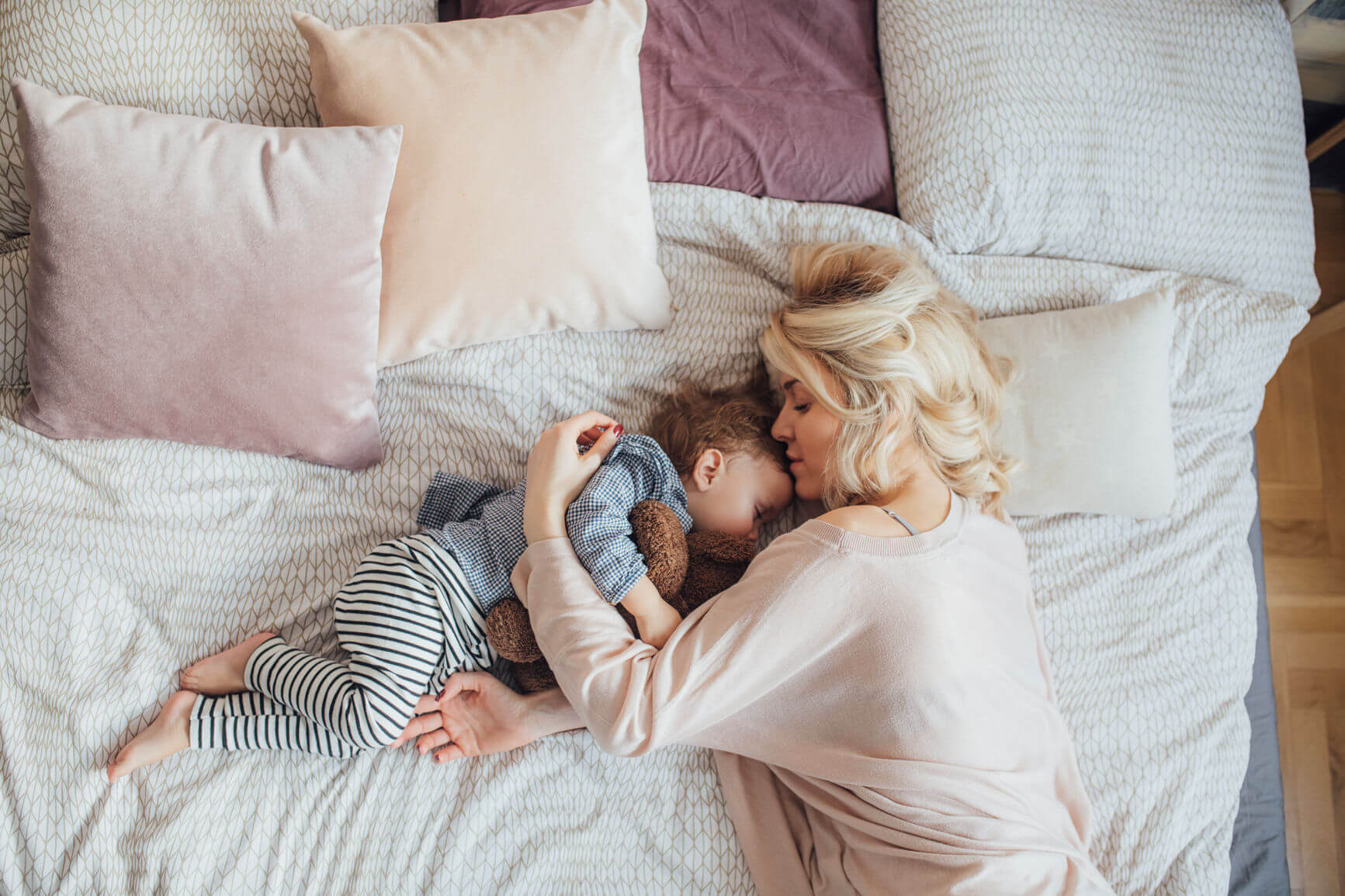 Woman and child asleep in bed