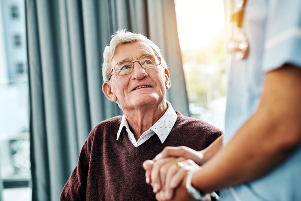 Elderly man holding hands with the doctor