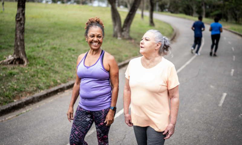 2 women walking together down road