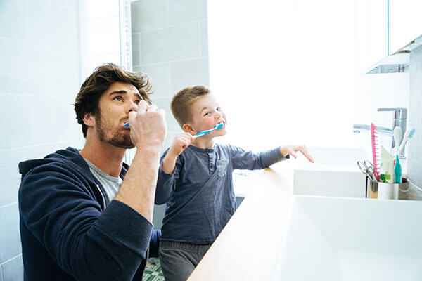Father and son brushing their teeth