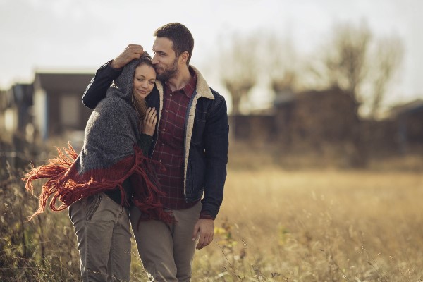 Young couple walking side by side in a field